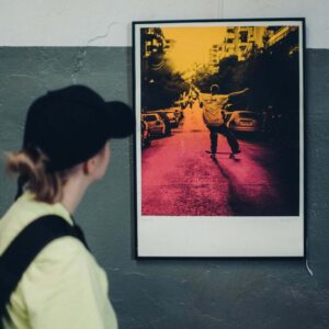 Osoba oglądająca kolorową fotografię prezentowaną podczas wystawy na Księżu Małym.