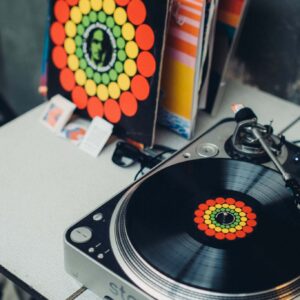 Gramofon z płytami winylowymi tworzący oprawę muzyczną wystawy.