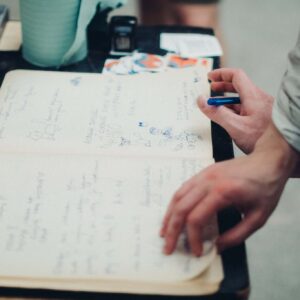 Zwiedzający wpisują swoje opinie do księgi gości podczas wystawy.