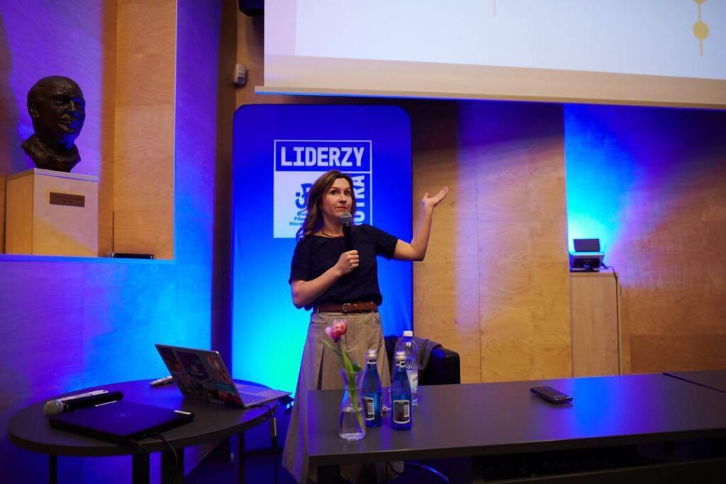 A speaker's talk during the Liderzy Jutra event, accompanied by a multimedia presentation.