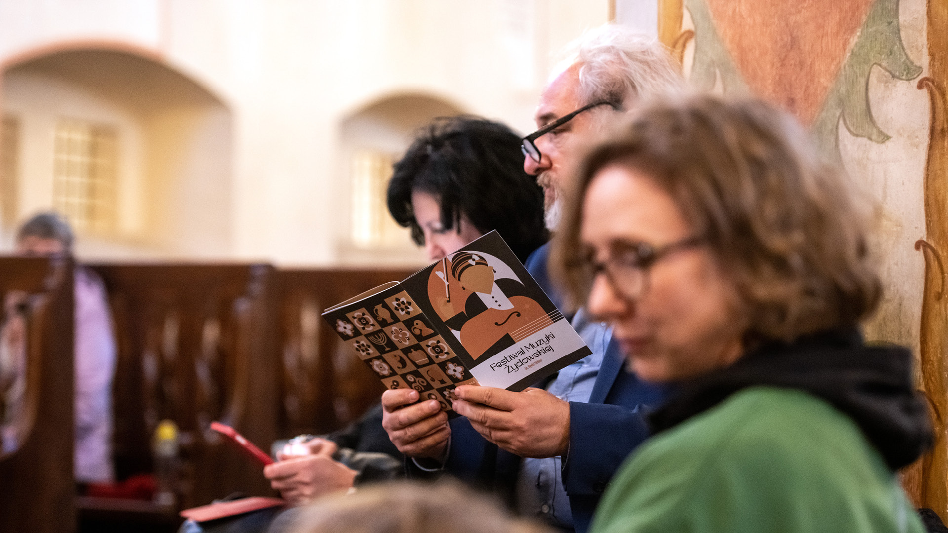 Identyfikacja wizualna festiwalu – publiczność z katalogiem wydarzenia Festiwalu Muzyki Żydowskiej im. Rywki Tiktiner, edycja 2025